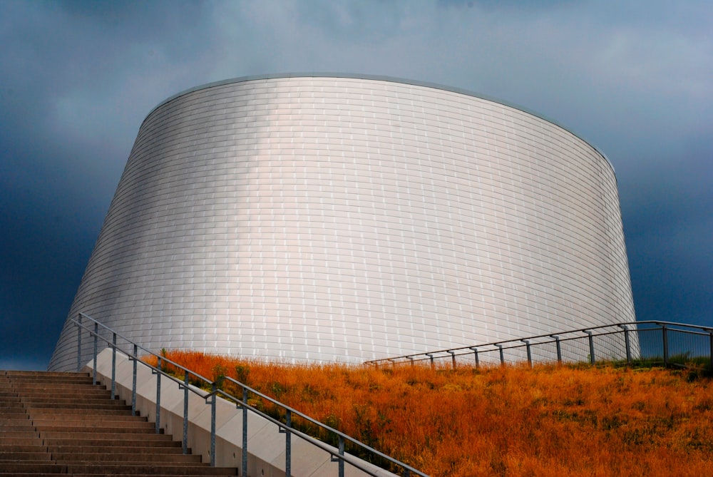 a large white building sitting on top of a lush green hillside