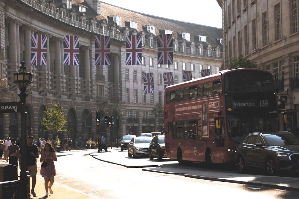 a red double decker bus driving down a street