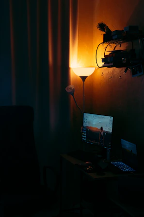 A cozy home office setup with warm lighting and a laptop ready for an online therapy session.