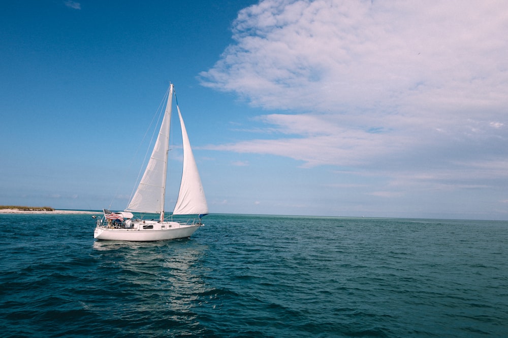 a sailboat sailing in the ocean on a sunny day