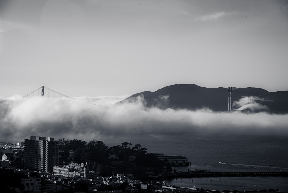 a black and white photo of a foggy city