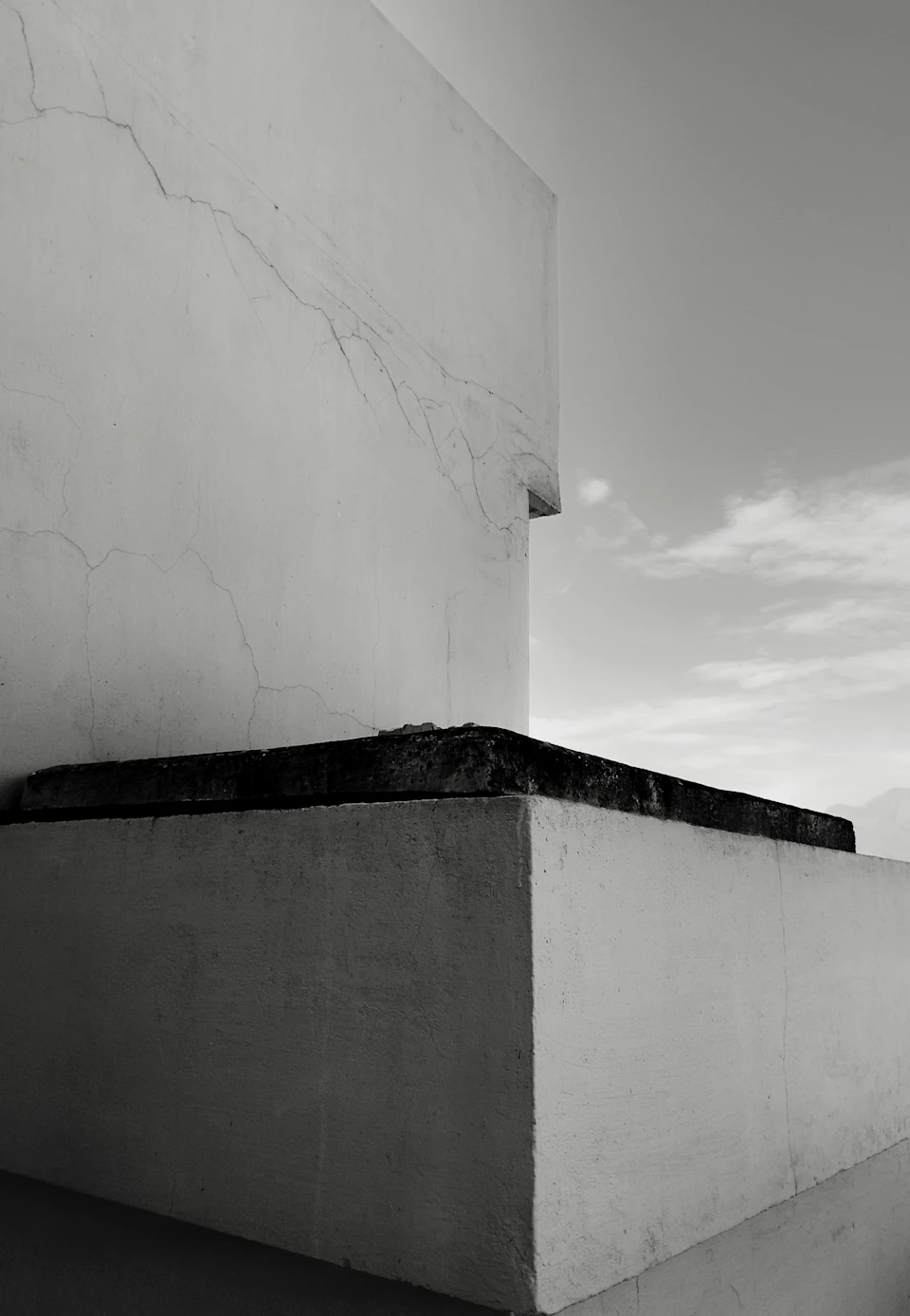 White building with black and white photograph taken from an angle focusing on corner