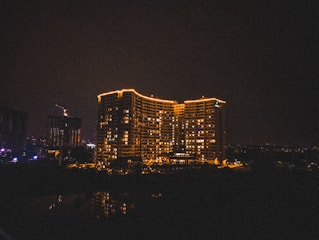 Night view of a completed building illuminated with warm lights.