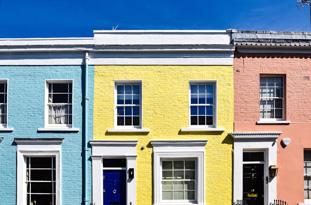 a row of multi - colored houses with a blue door