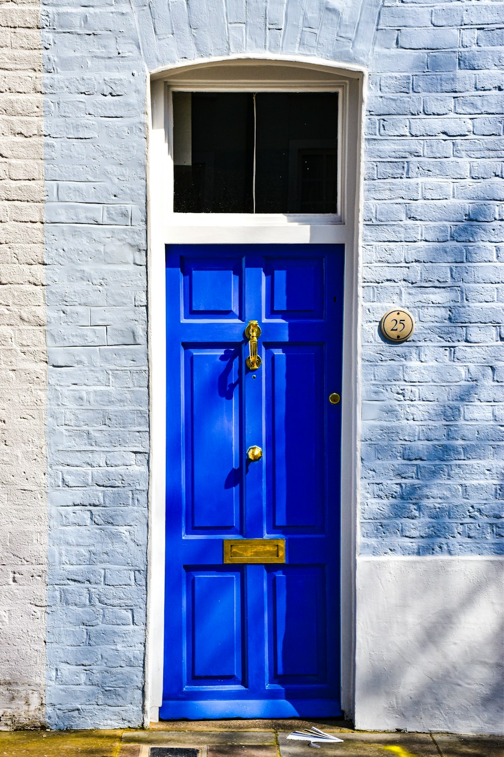 a blue door with a yellow handle on a brick building