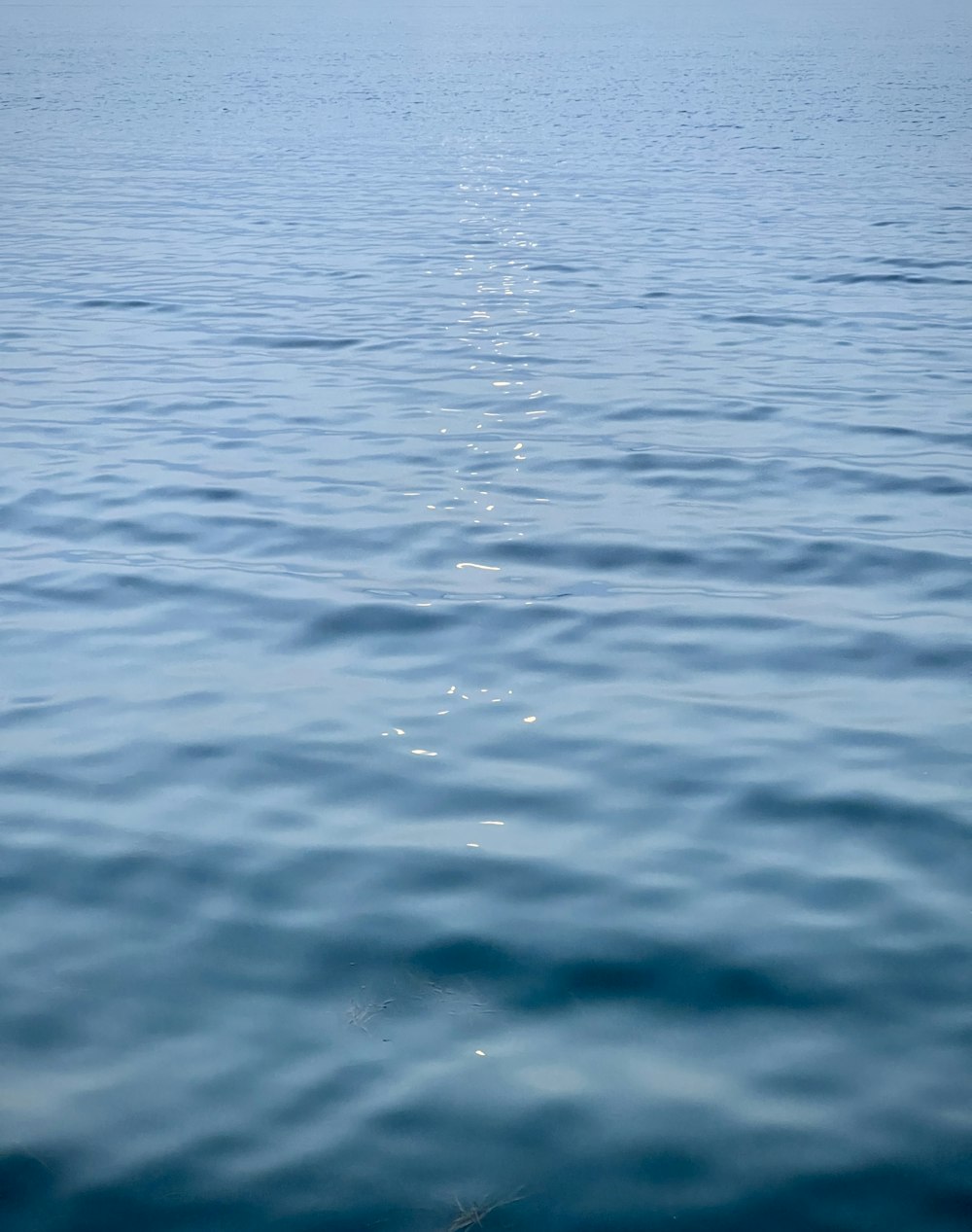 a large body of water with a boat in the distance