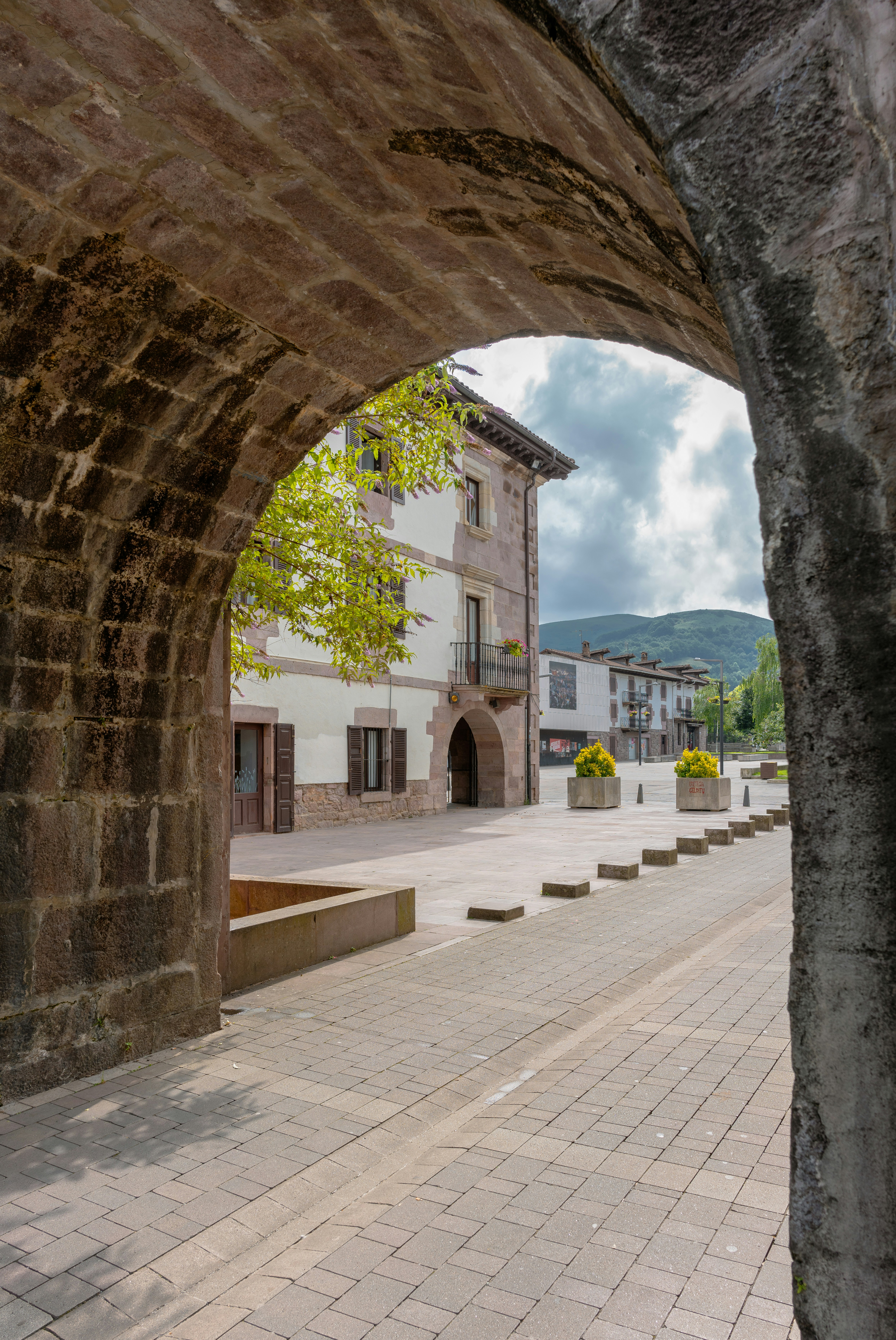 a stone arch with a building in the background