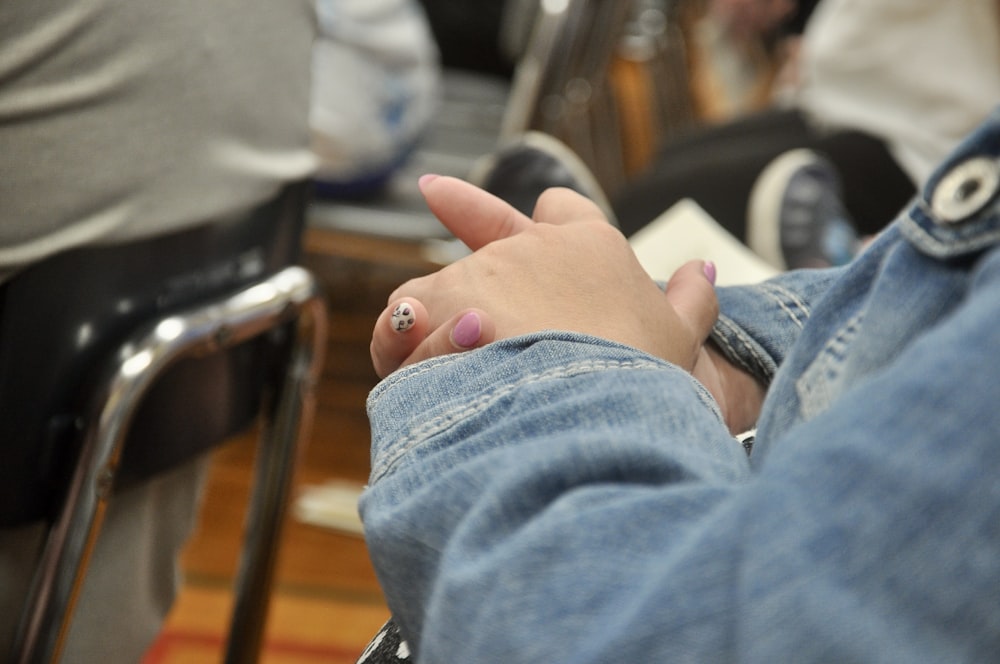 a person sitting in a chair with a ring on their finger