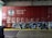 A red freight train car covered with graffiti and the words 'Canadian Pacific Railway' prominently displayed. There are various tags and artistic designs in shades of white and blue on the train car. The setting appears to be inside a warehouse or an industrial area, with a metal roller door and a trash bin visible to the side. The floor consists of concrete with a yellow safety line along the edge.