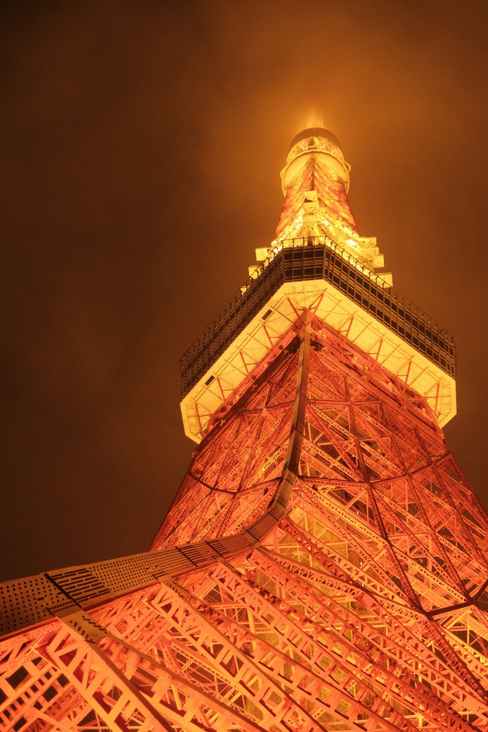 the Tokyo tower is lit up at night