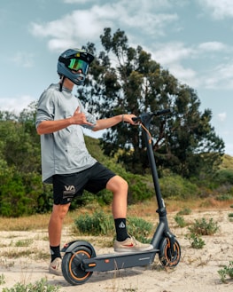 a man riding a scooter on a dirt road