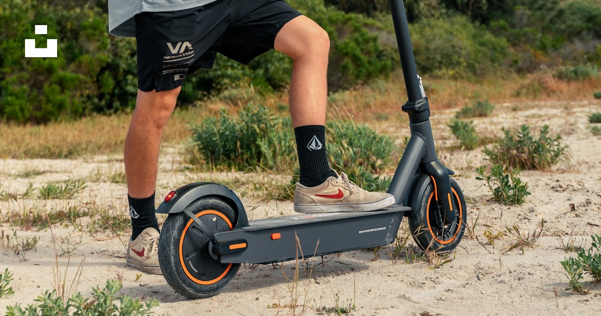 Foto zum Thema Ein mann, der einen roller auf einer unbefestigten