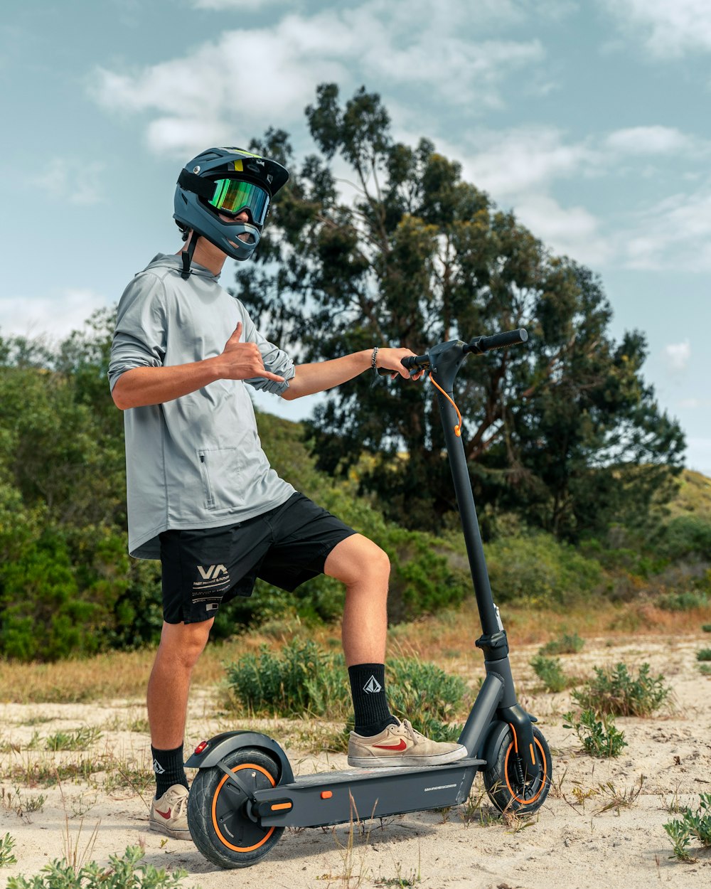 a man riding a scooter on a dirt road