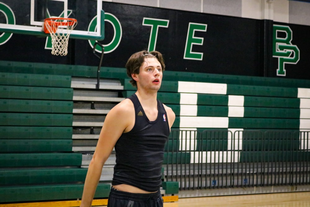 a young man standing on top of a basketball court