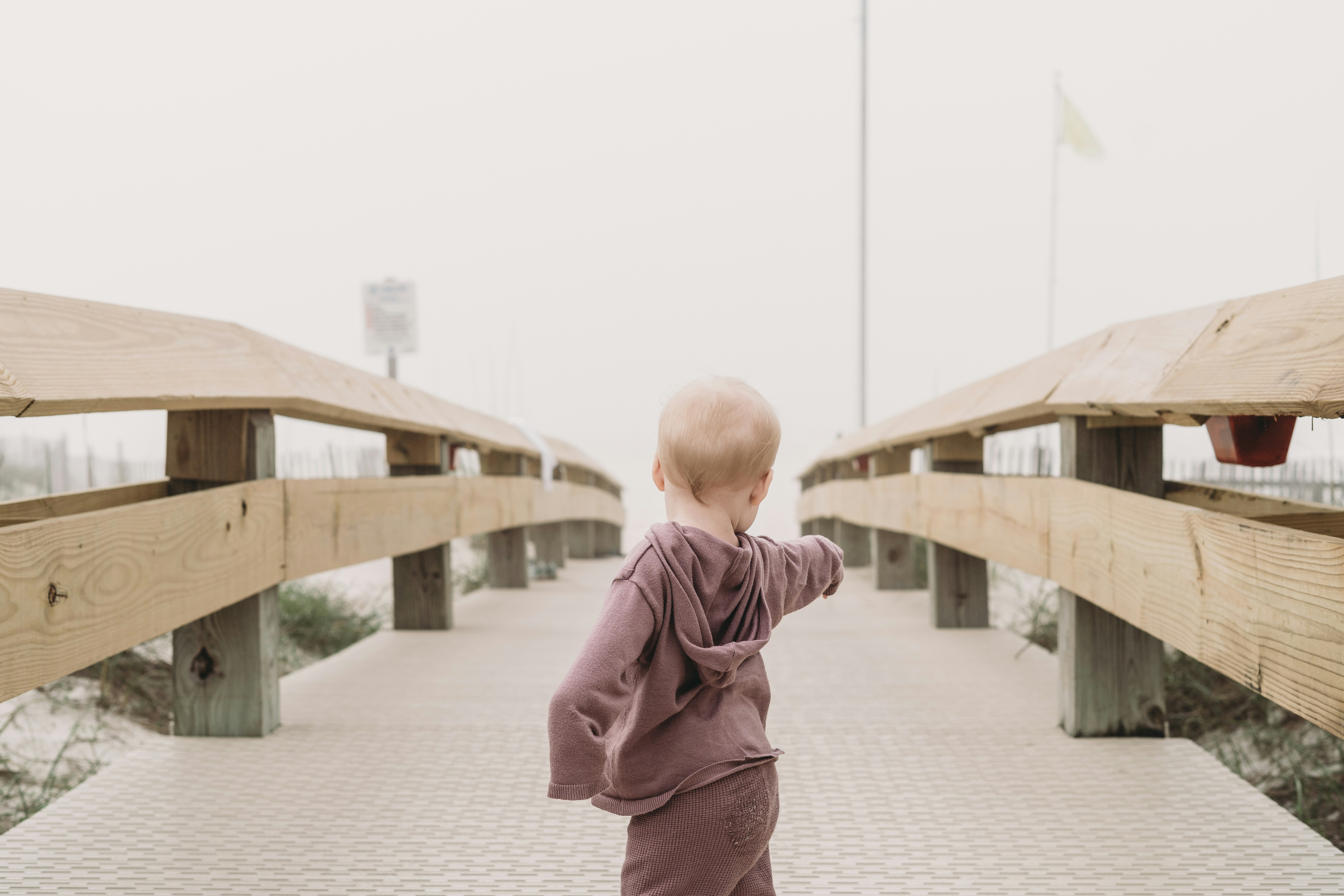 A small child walking across a wooden bridge photo – Free Orange beach ...