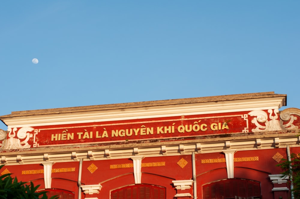 a red building with a moon in the sky