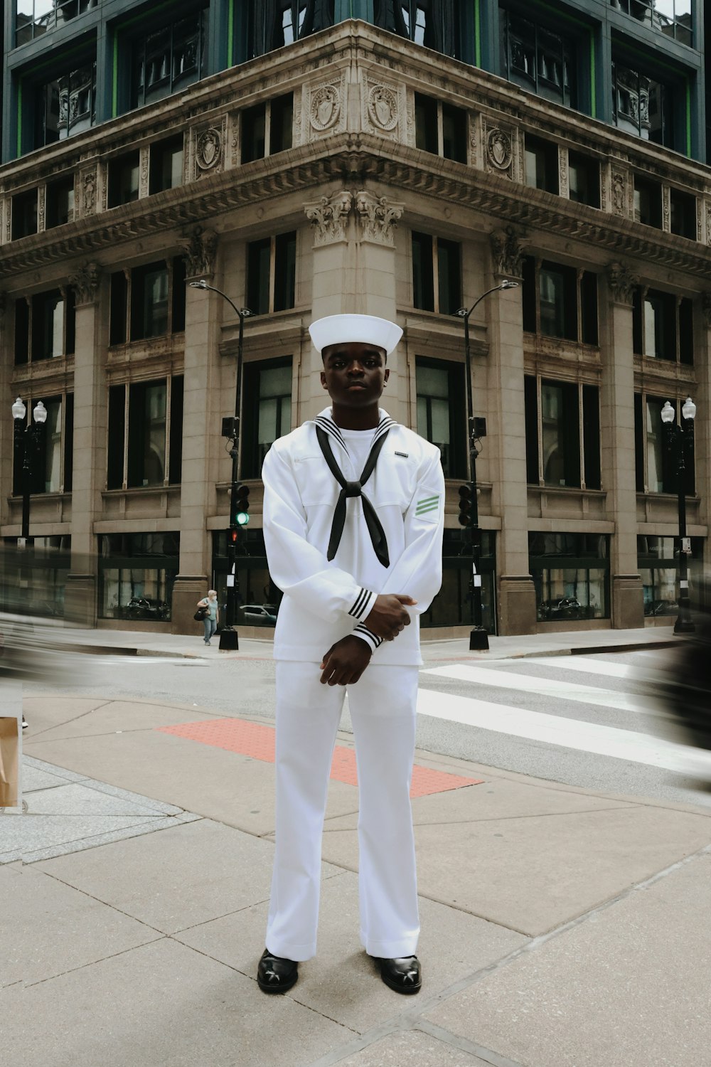 a man in a sailor's uniform standing in front of a building