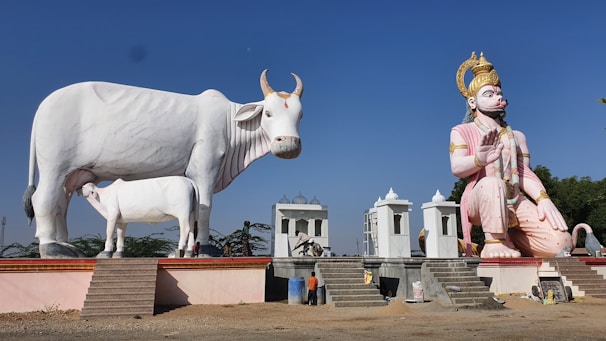 Devotees caring for a gentle cow under the shade of a tree, symbolizing Gau Mata ki Sewa.