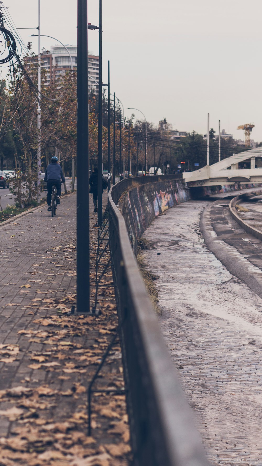 a man riding a bike down a street next to a train track