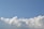 A clear sky with fluffy, white clouds at the bottom part of the image. The clouds appear soft and billowy against a blue backdrop.