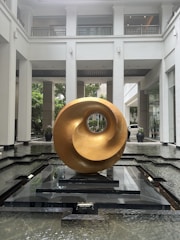 An artistic brass sculpture displayed in a bright setting.