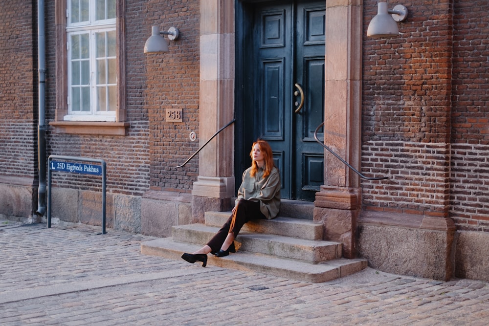 a woman sitting on the steps of a building