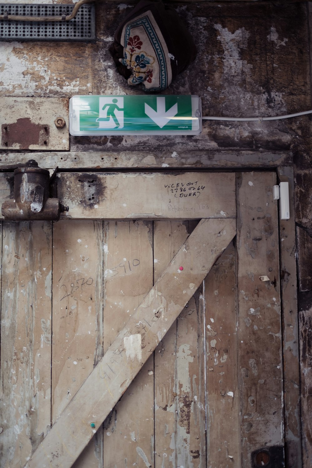 a wooden door with a green and white sign on it