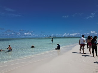 Tourists enjoying a sunny beach with clear blue waters