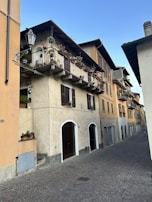 A narrow cobblestone street lined with colorful houses in a charming European village.