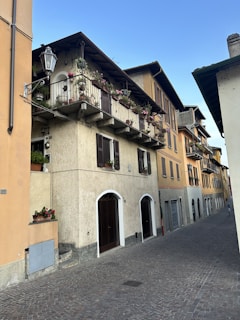 A narrow cobblestone street lined with colorful houses in a charming European village.