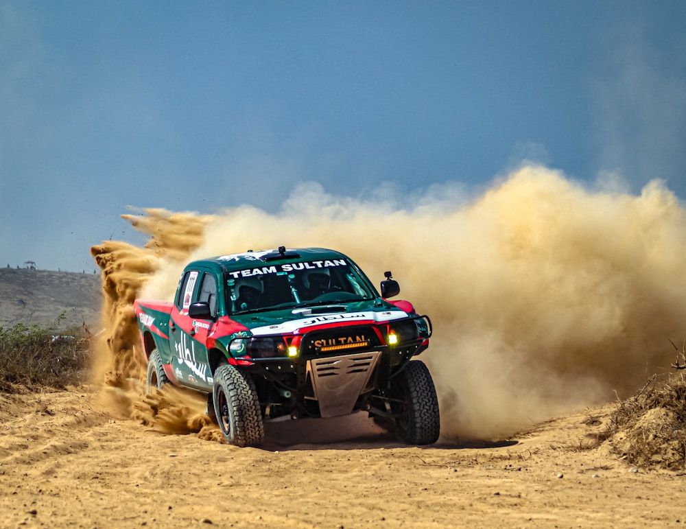 a truck driving down a dirt road in the desert