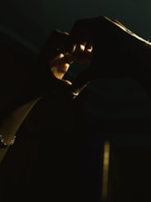 Pastel purple background with gentle hands forming a heart shape.