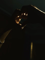 Close-up of hands forming a heart shape against a soft background.