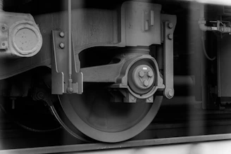 a black and white photo of the wheels of a train