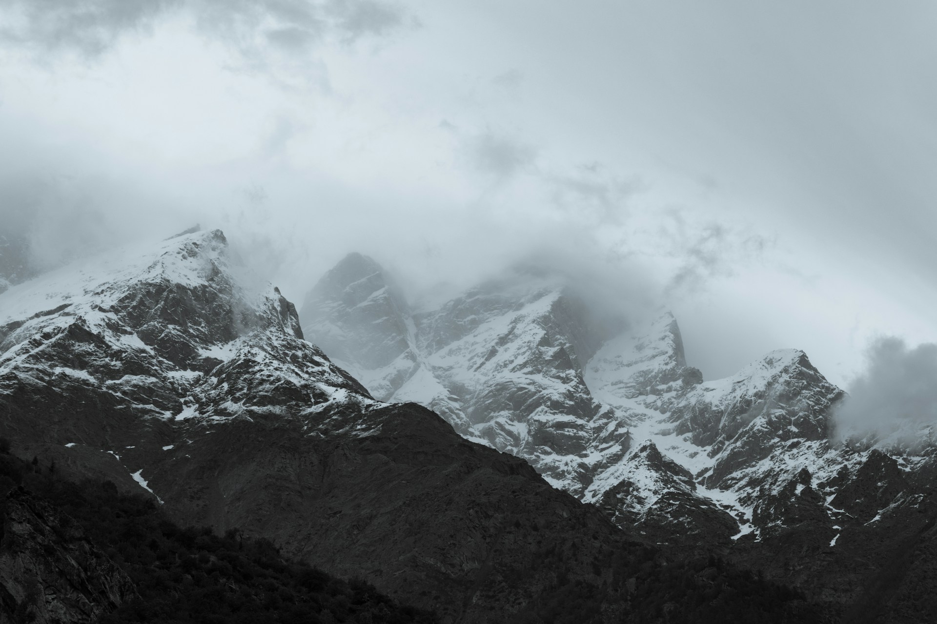 a mountain covered in snow under a cloudy sky