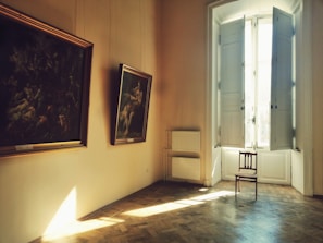 A serene living room bathed in natural light, arranged according to vastu principles with soft spiritual artwork on the walls.