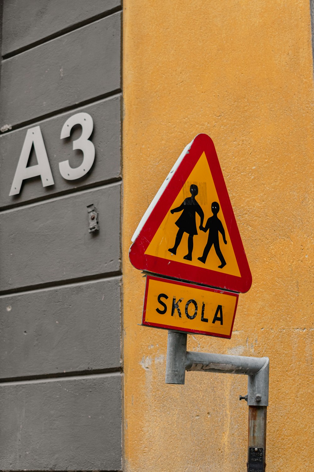 a yellow and red street sign on the side of a building