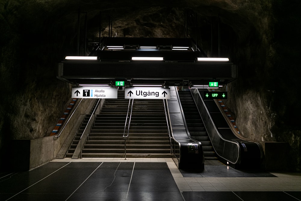 an escalator in a subway station with stairs leading up to it