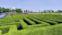 Photo of a large modular maze set up on a sunny farm landscape with families enjoying the pathways.