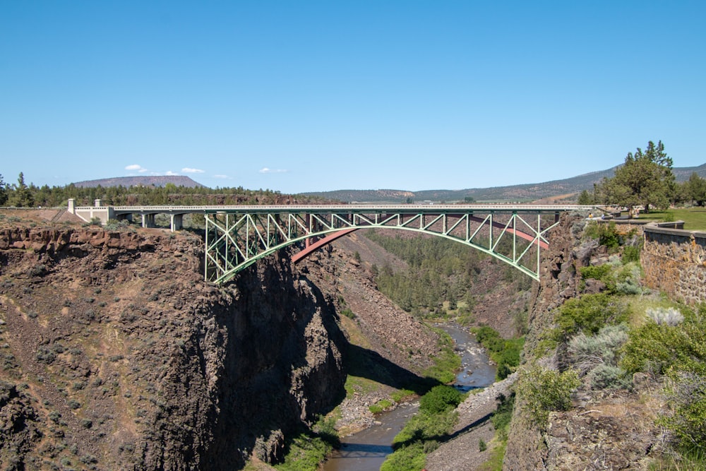 a bridge over a canyon with a river below