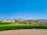 A freshly landscaped garden with vibrant flowers and neatly trimmed shrubs in front of a mountain home.