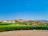 A freshly landscaped garden with vibrant flowers and neatly trimmed shrubs in front of a mountain home.
