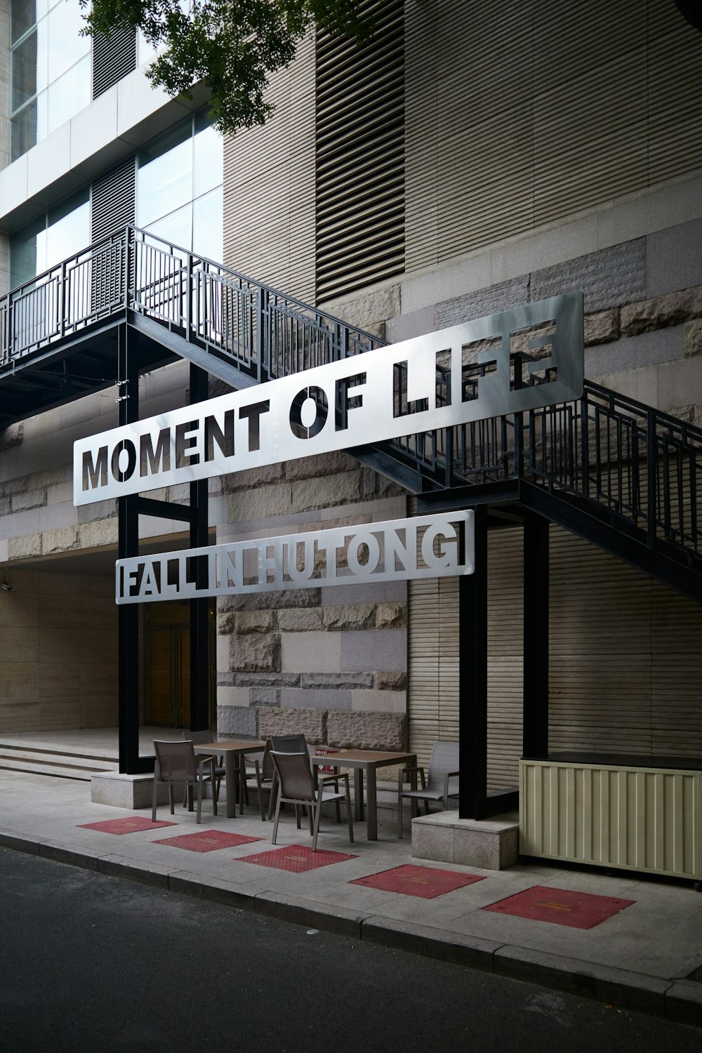 a sign that says moment of lift hanging from the side of a building