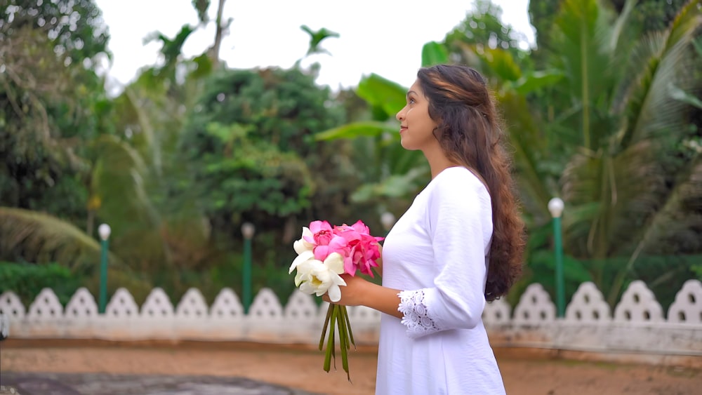 a woman holding a bouquet of flowers in her hands