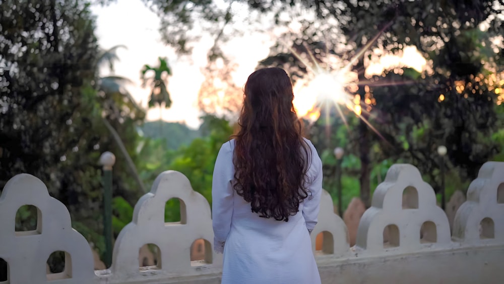 a woman standing in front of a white fence