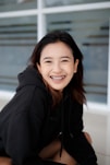 a woman sitting on the ground with a smile on her face