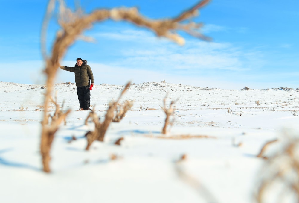 a man standing in the snow pointing at something