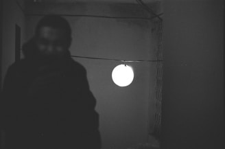 A flickering light bulb casting shadows in a dark room.