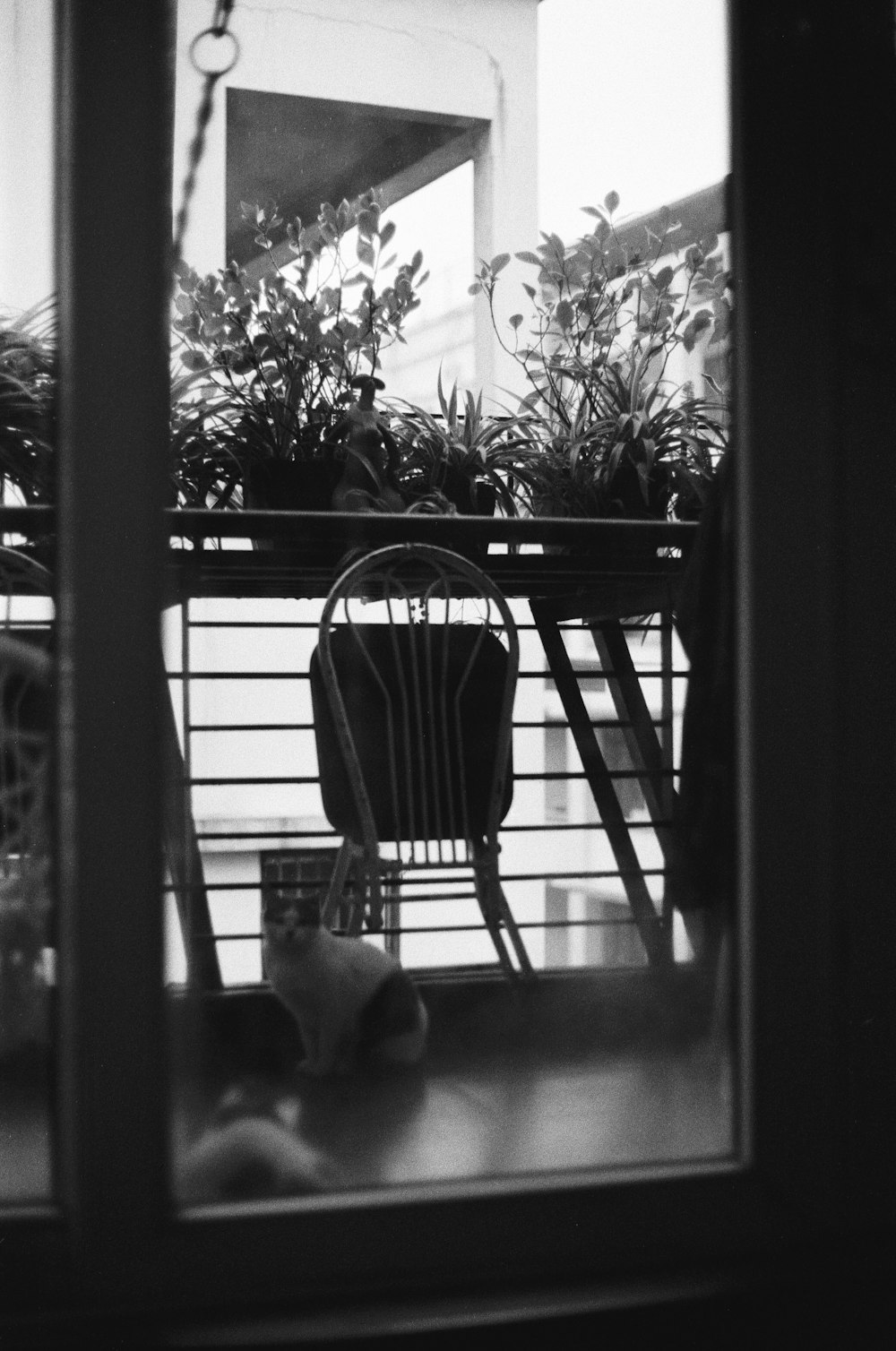 uma foto em preto e branco de uma cadeira em uma varanda