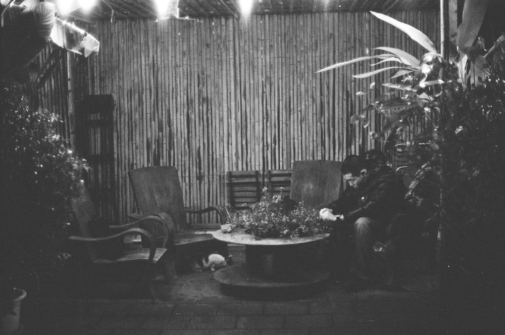 uma foto em preto e branco de um homem sentado em uma cadeira